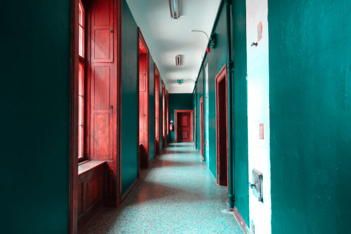 A,Corridor,With,Green,Walls,And,Red,Doors.